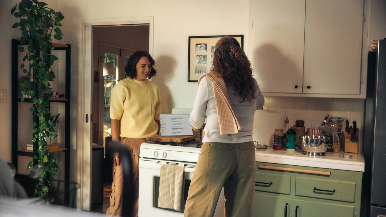 Duas amigas conversando na cozinha de casa enquanto uma delas prepara o jantar.