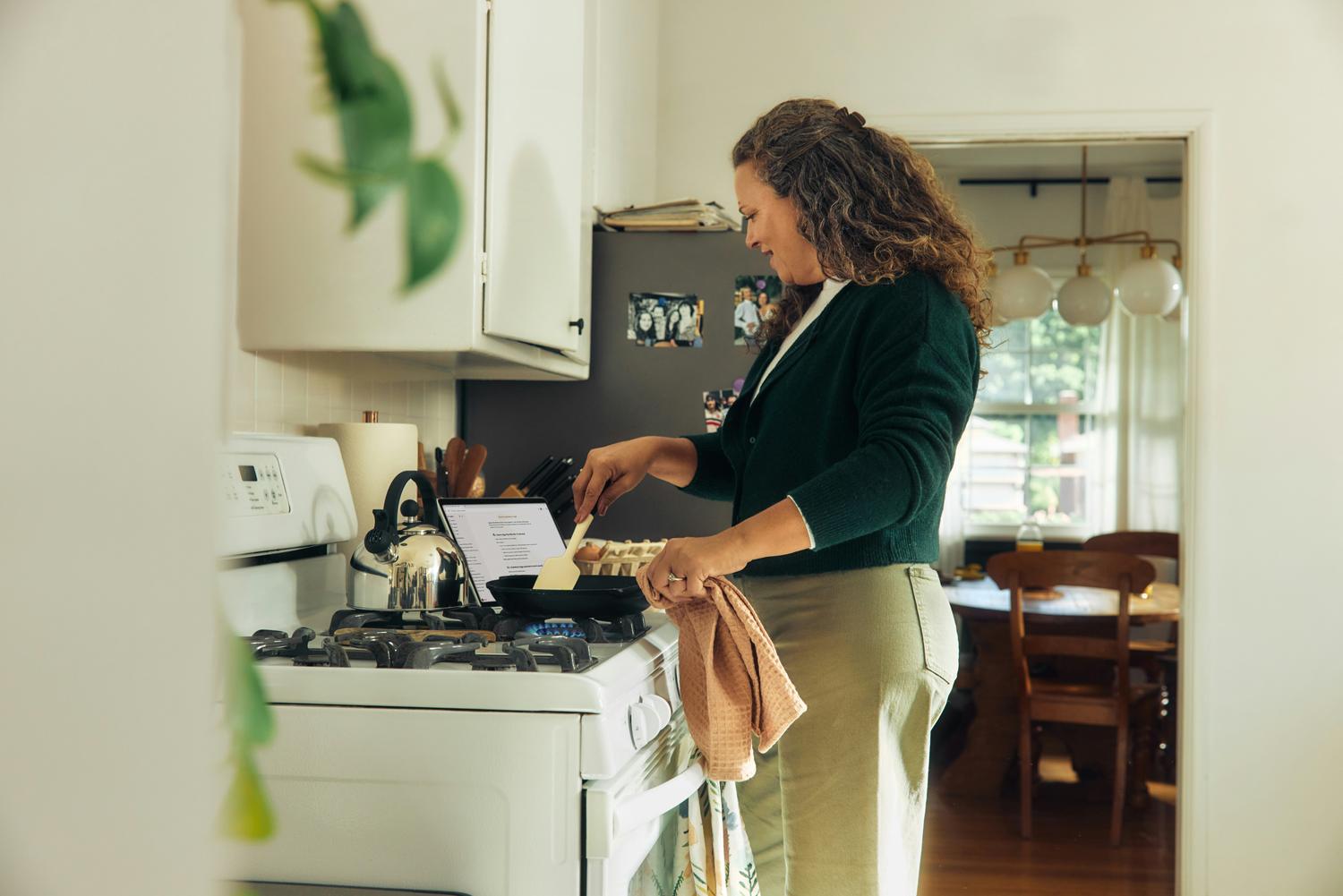 Mulher preparando o jantar na cozinha de casa, tranquila.